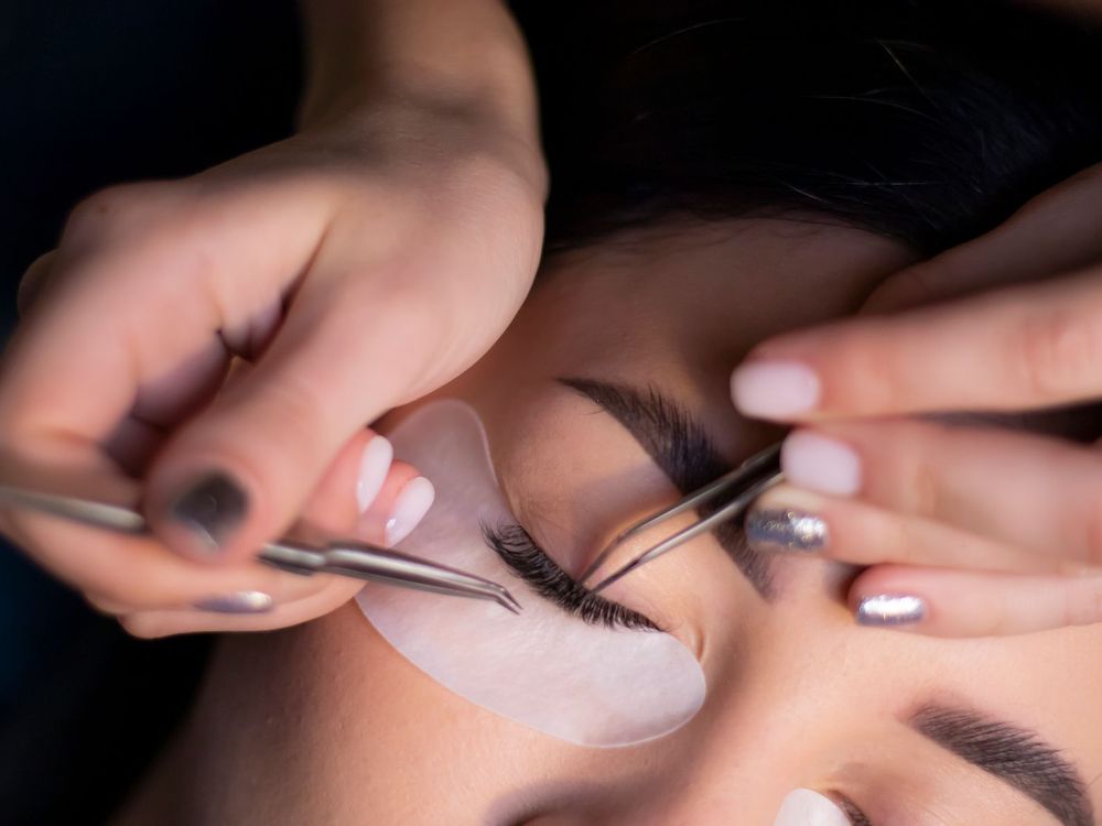 Wimpern werden mit Pinzette angesetzt