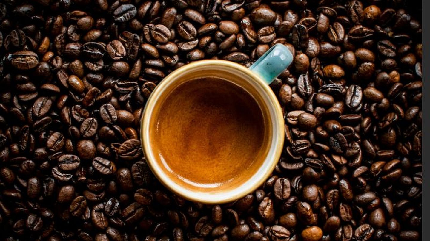 Tasse Espresso von oben, eingebettet in ein dichtes Bett aus frisch gerösteten Kaffeebohnen