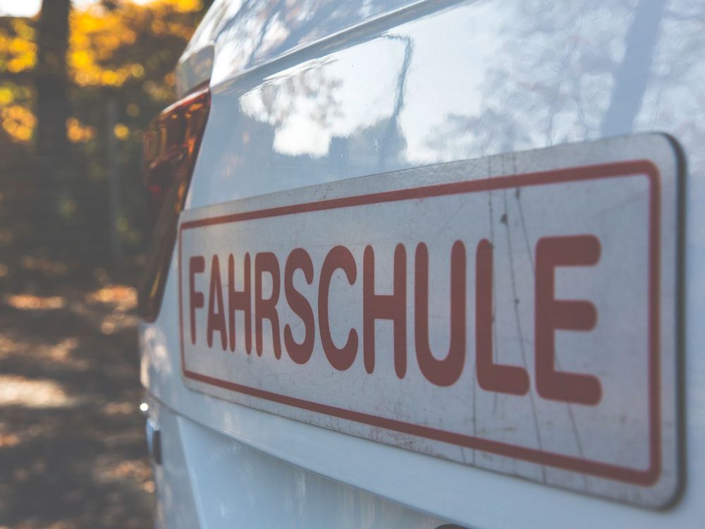 Fahrschulschild auf dem Dach eines weißen Autos