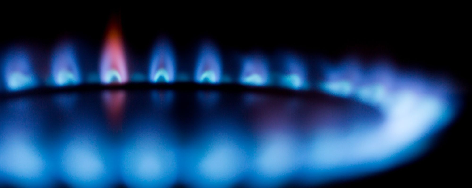 Blue gas flames on a burner ring in the dark