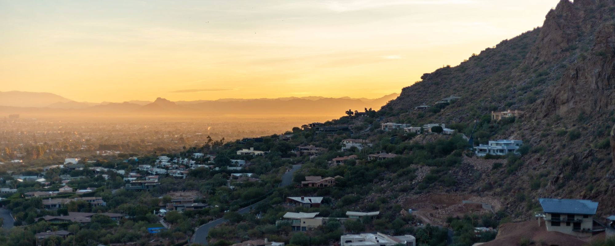 Phoenix in the evening haze, houses on the slope of a desert mountain