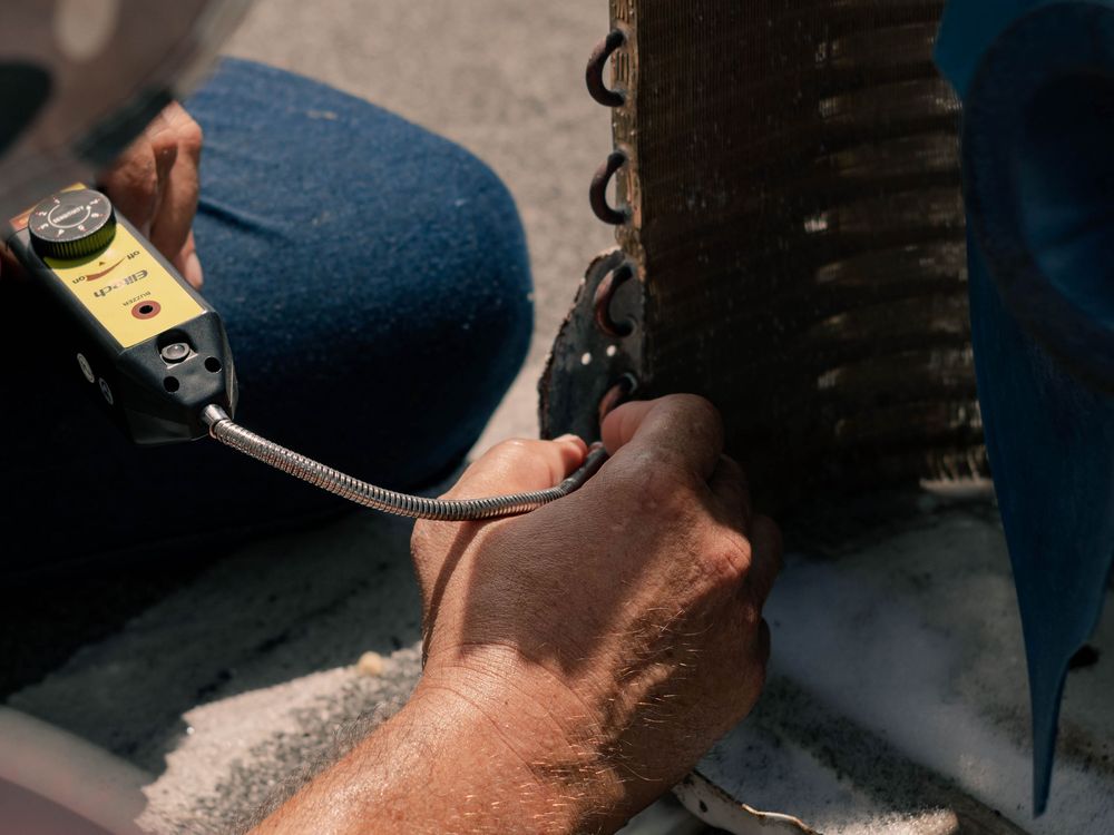 Technician testing an outdoor coil with a meter
