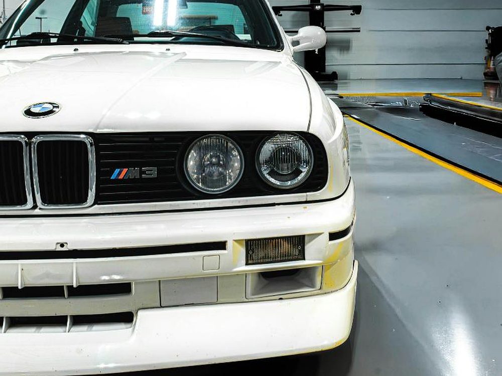 Weißer BMW in der hellen Werkstatthalle von Motorhaus Spandau vor der Hauptuntersuchung
