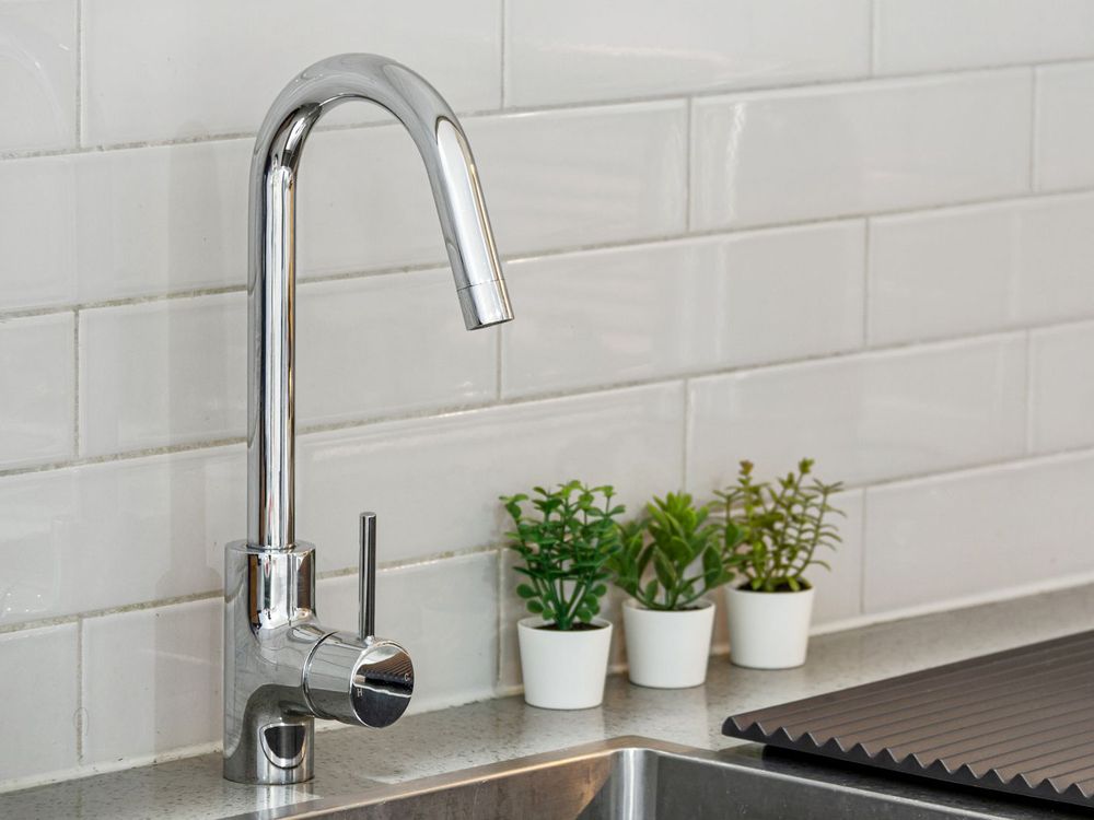 Chrome kitchen faucet over a steel sink