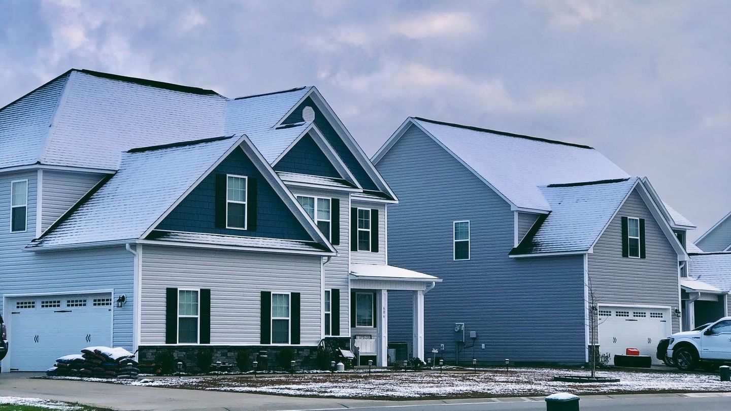 Houses on a suburban street with hail on the lawns