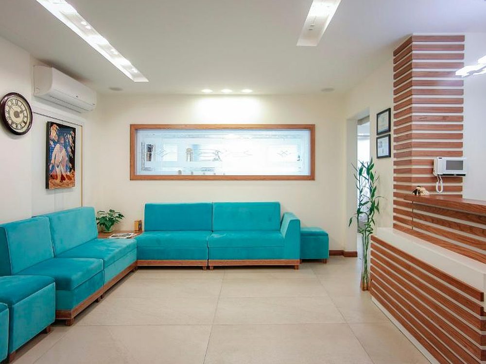 Einladendes Wartezimmer mit türkisen Sofas und Holzverkleidung